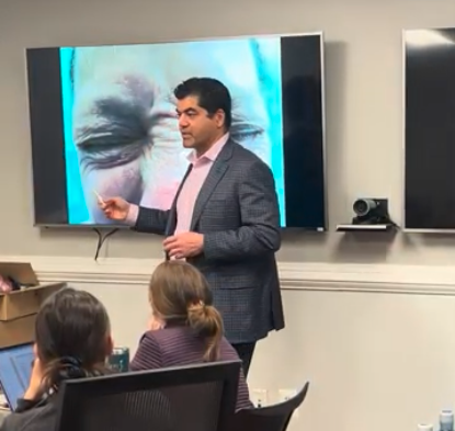 Dr. Amir Bajoghli presenting at a dermatology lecture